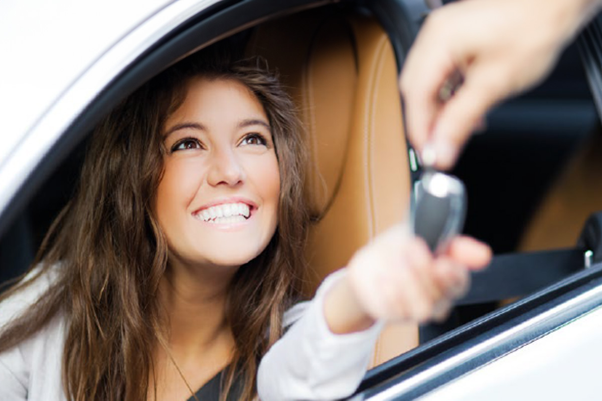 Bild zeigt ein eine Frau in einem Auto dioe einen Schlüssel nimmt